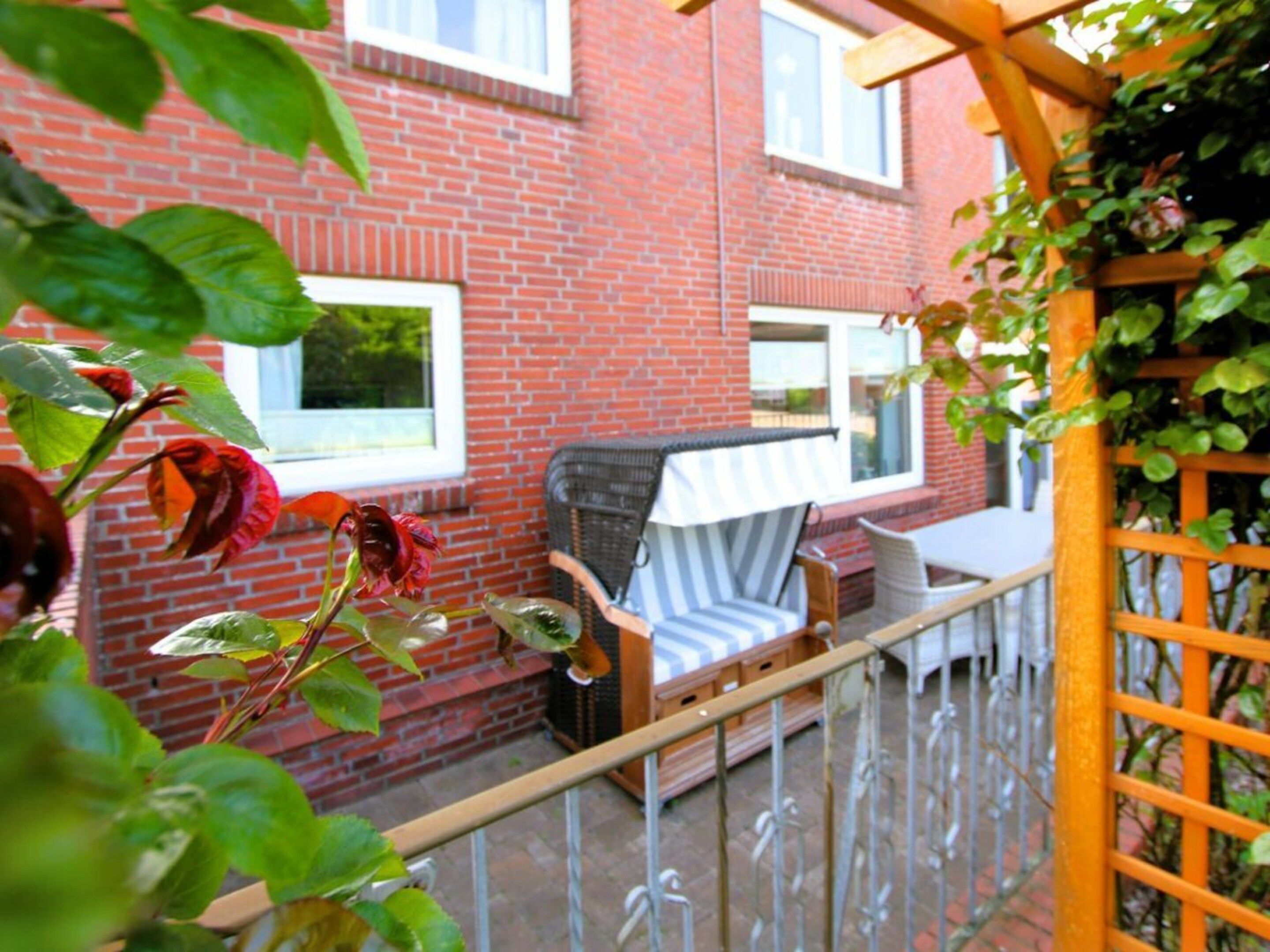A brick building with a balcony, a chair, and a table.