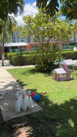 Ein Rasenplatz mit einer Bowlinganlage und einer kleinen Laube.