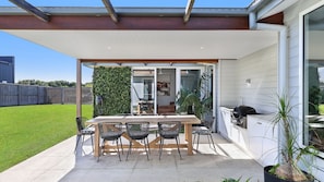 A covered patio with a table and chairs, a grill, and a view of the backyard. - Diana's Joy - Luxury, Space, Golf & Coastal Living in Warrnambool (Warrnambool)