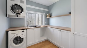 A laundry room with a washing machine, a dryer, and a sink. - Diana's Joy - Luxury, Space, Golf & Coastal Living in Warrnambool (Warrnambool)