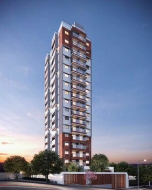 A high-rise residential building with multiple balconies, a modern architectural design, and a clear sky in the background. - 1 Bedroom Queen Jardins Pool Garage Metro PKS48 (São Paulo)