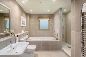 A modern bathroom with a bathtub, shower, and dual sinks. - The Derwent Spa (Hexham)