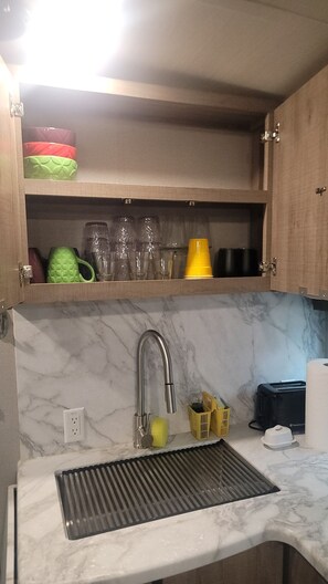 A kitchen with a marble countertop, a stainless steel sink, and a toaster.
