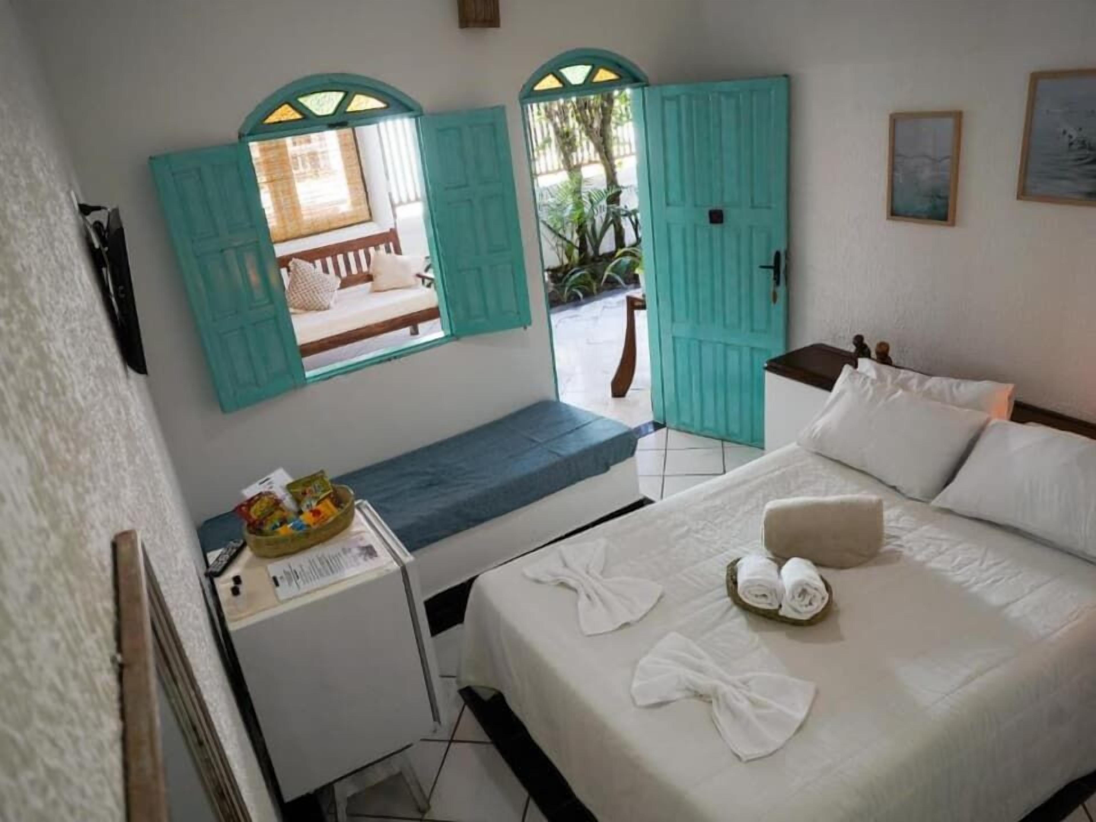 Una habitación con cama, escritorio y ventana con vista al exterior.