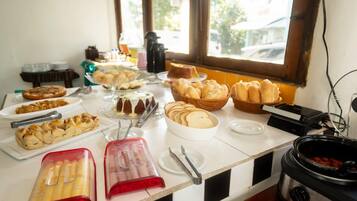 Una mesa de buffet con diversos alimentos y utensilios.