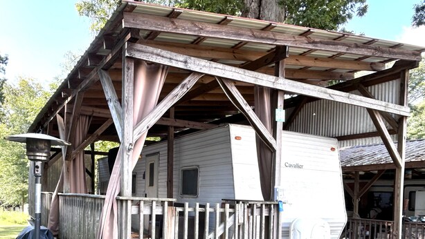 A rustic cabin with a porch, a chimney, and a covered area. - Anchor’s Rest at Swann’s Marina
Comfort • Hot Tub • Fire Pit • Pet Friendly (Dandridge)