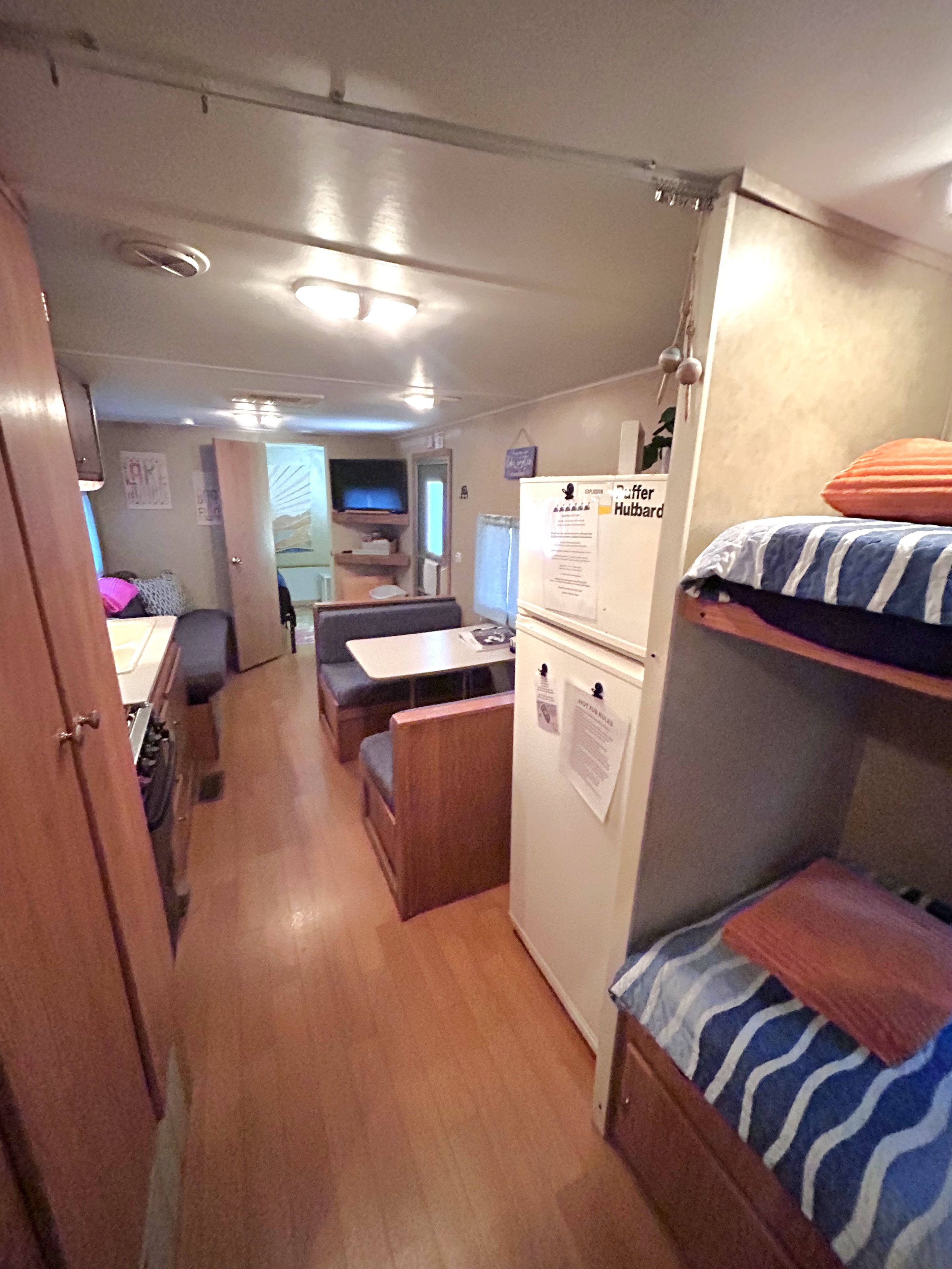 Un espacio habitable compacto con kitchenette, zona de estar y cama.