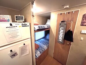A compact room with bunk beds, a laundry area, and various informational signs. - Anchor’s Rest at Swann’s Marina
Comfort • Hot Tub • Fire Pit • Pet Friendly (Dandridge)