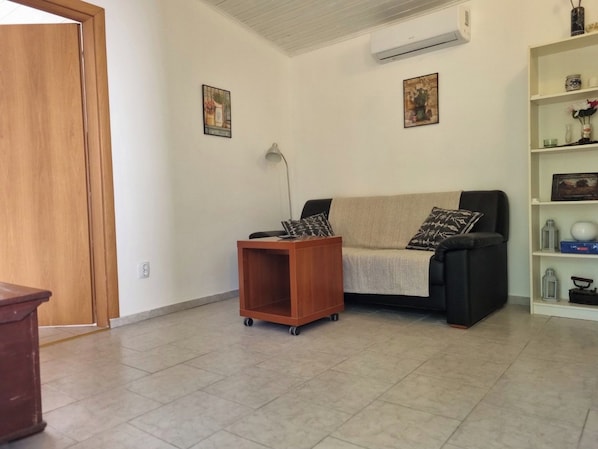 A living room with a sofa, a small wooden table, and a bookshelf.