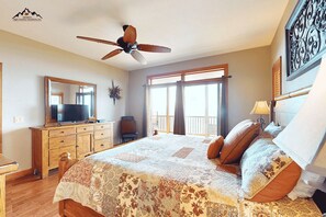 A bedroom with a large bed, a ceiling fan, a TV, a dresser, and a balcony with a view. - Luxury 2 Bedroom Condo with Long Range Views on Sugar Mountain (Sugar Mountain)