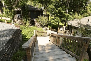 A wooden staircase leading to a cabin surrounded by trees. - Sleep at The Slopes! 2 Bedroom Round House Slopesider #1 (Sugar Mountain)