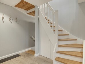 A staircase with wooden steps and white railings leading to an upper floor. - Holiday Apartment in Sylt With 2 Bedrooms (Sylt)