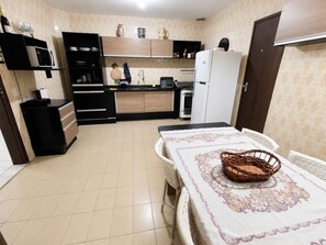 Eine kompakte Küche mit modernen Geräten, ein Essbereich mit Tisch für zwei Personen und eine kleine Sitzecke.