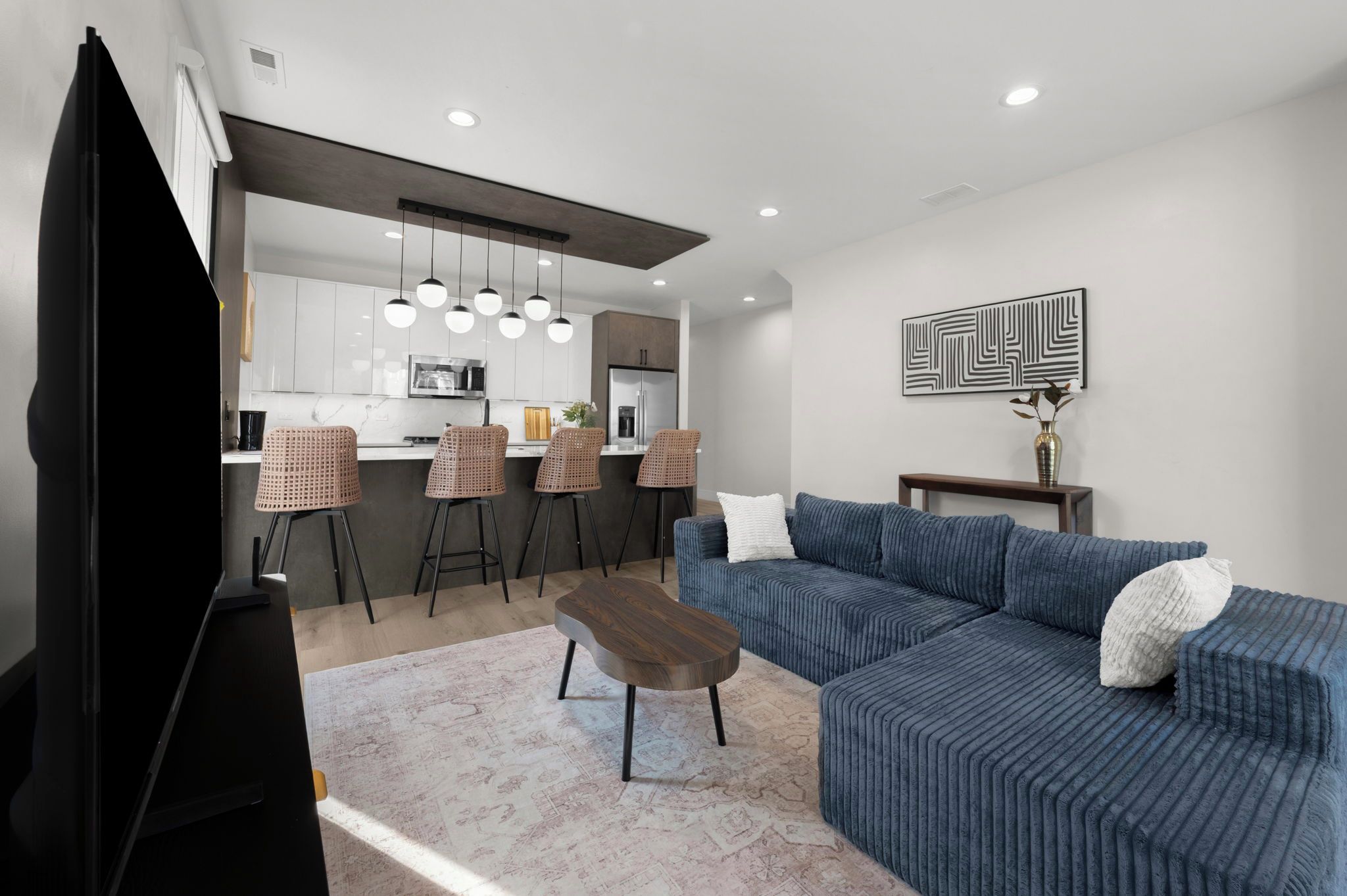 A modern living room with a blue sofa, a coffee table, and a TV.
