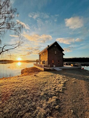 A wooden cabin with a dock by a lake at sunset. - Front-row seat to nature's spectacle (Lönsboda)