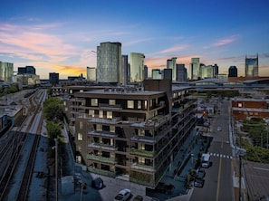 Ein mehrgeschossiges Gebäude mit moderner Architektur, direkt neben einem Gleis.