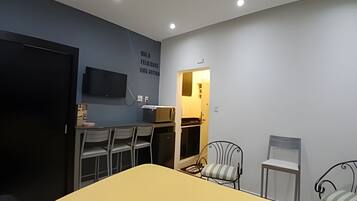 Una habitación pequeña y moderna con cama, escritorio y dos sillas.