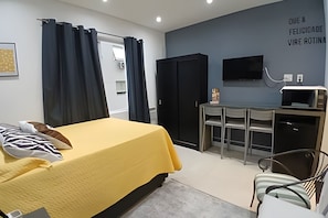 A bedroom with a bed, a desk, a chair, and a TV. - SHB - Pequeno Paraíso Exclusivo (Santos)