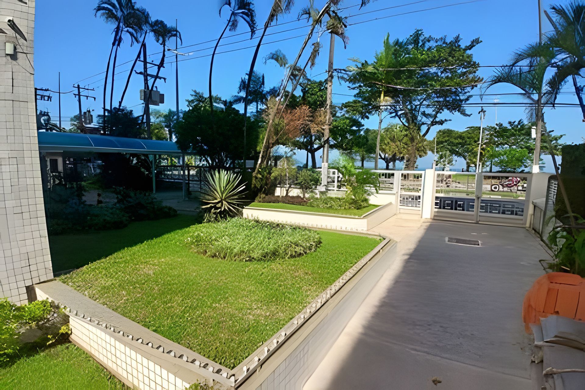 Un patio con un sendero empedrado, una zona de estar techada y diversas plantas.