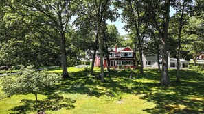 A house surrounded by trees in a grassy area. - Cozy Lake House on Lake Erie (Bay Village)