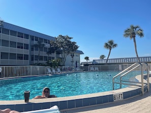 Una piscina con un indicador de profundidad de 6 pies y medio, rodeada por una valla blanca y palmeras.