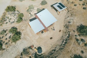 An aerial view of a property with a large building, a smaller structure, and a tent. - Cobalt Cabin by Homestead Modern (Yucca Valley)