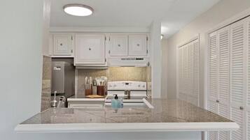 A kitchen with white cabinets, a built-in stove, and a countertop.