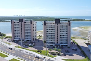Two high-rise buildings with a marina and beach in the background. - Beachfront Islands End Condo | Gorgeous Big Carlos Pass Views | Heated Pool + Hot Tub | Free Parking (Fort Myers Beach)