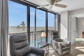 A balcony with two leather chairs, a small table, and a view of the beach. - Beachfront Islands End Condo | Gorgeous Big Carlos Pass Views | Heated Pool + Hot Tub | Free Parking (Fort Myers Beach)