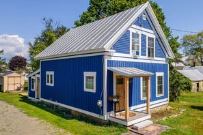 A single-story blue house with a gabled roof, a front porch, and a small attached garage. - The Blue House Hideaway | Less than 20 Minutes to Sugarloaf (Kingfield)