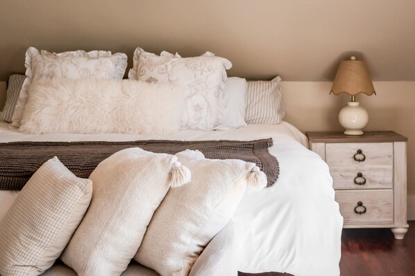 A neatly made bed with white bedding and decorative pillows, a brown throw blanket, and a bedside table with a lamp. - The Blue House Hideaway | Less than 20 Minutes to Sugarloaf (Kingfield)