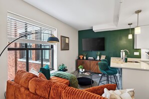 Ein modernes Apartment mit Wohnzimmer, Essbereich und Küche.