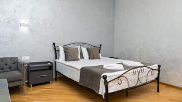 A bedroom with a bed, bedside tables, a chair, and a wardrobe.