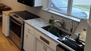 A kitchen with a built-in oven, a sink, and a window.