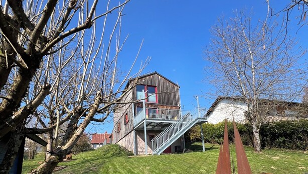 A park with a wooden building, a metal staircase, and a sculpture. - Vulkaneifel Artists' House (Mückeln)