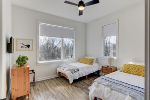 A bedroom with two beds, a ceiling fan, and large windows. - Spacious 4-Bedroom Townhome in Excellent Nashville Area • 10 Min to Broadway (Nashville)