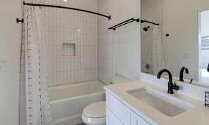 Un baño moderno con bañera, inodoro y lavamanos.