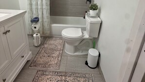 Ein Badezimmer mit Toilette, Bidet, Dusche und einem kleinen Waschbecken.