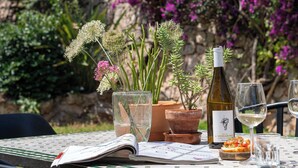 An outdoor dining table with a wine bottle, glasses, and a menu. - Beautiful villa on the Costa Blanca, with a pool, ocean view, garden, and close to the beach and Dénia. (Pego)