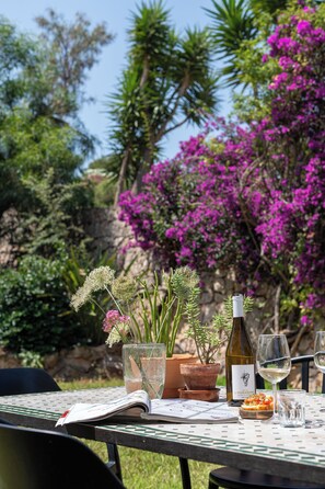 An outdoor dining table with a wine bottle, glasses, and a menu. - Beautiful villa on the Costa Blanca, with a pool, ocean view, garden, and close to the beach and Dénia. (Pego)