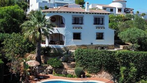 A white villa with a pool, surrounded by greenery and trees. - Beautiful villa on the Costa Blanca, with a pool, ocean view, garden, and close to the beach and Dénia. (Pego)