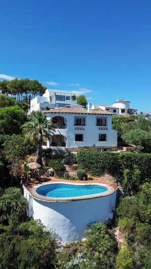 A white villa with a pool, surrounded by greenery and trees. - Beautiful villa on the Costa Blanca, with a pool, ocean view, garden, and close to the beach and Dénia. (Pego)