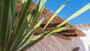 A patio with a round table and wicker chairs, surrounded by terracotta tiles and a white wall. - Beautiful villa on the Costa Blanca, with a pool, ocean view, garden, and close to the beach and Dénia. (Pego)