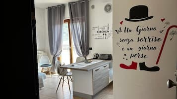 Una cocina moderna con una isla central, un comedor con sillas y una pared con una cita motivacional.