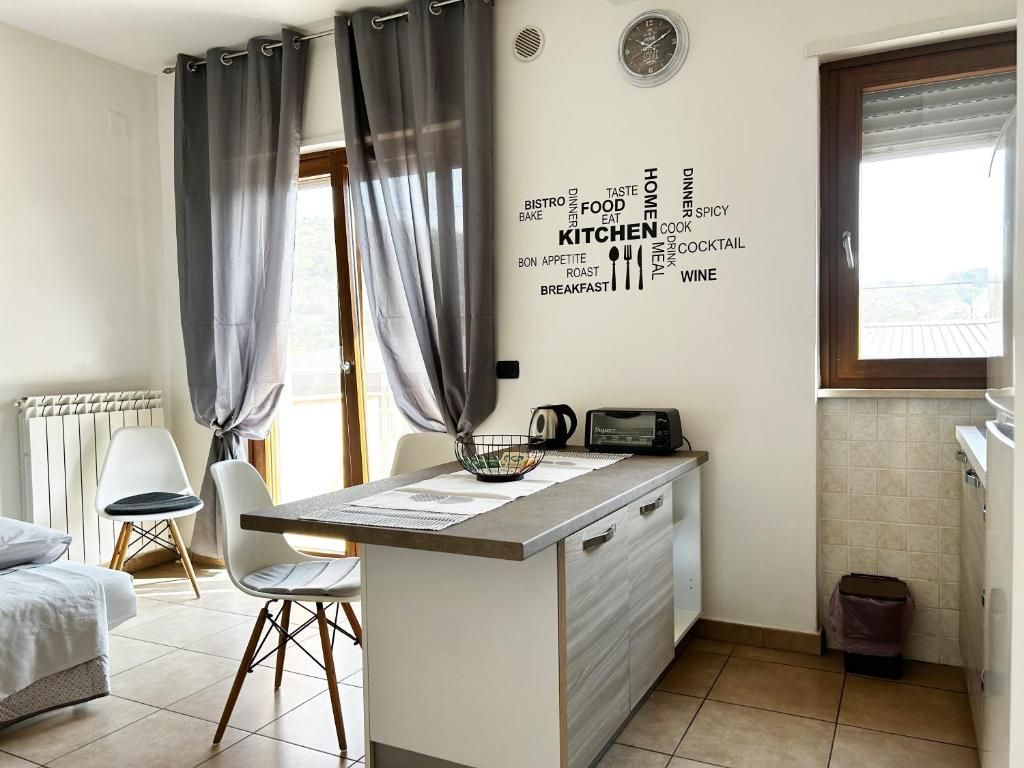 Una cocina compacta con un mural de palabras, una pequeña mesa de comedor y una sola silla.