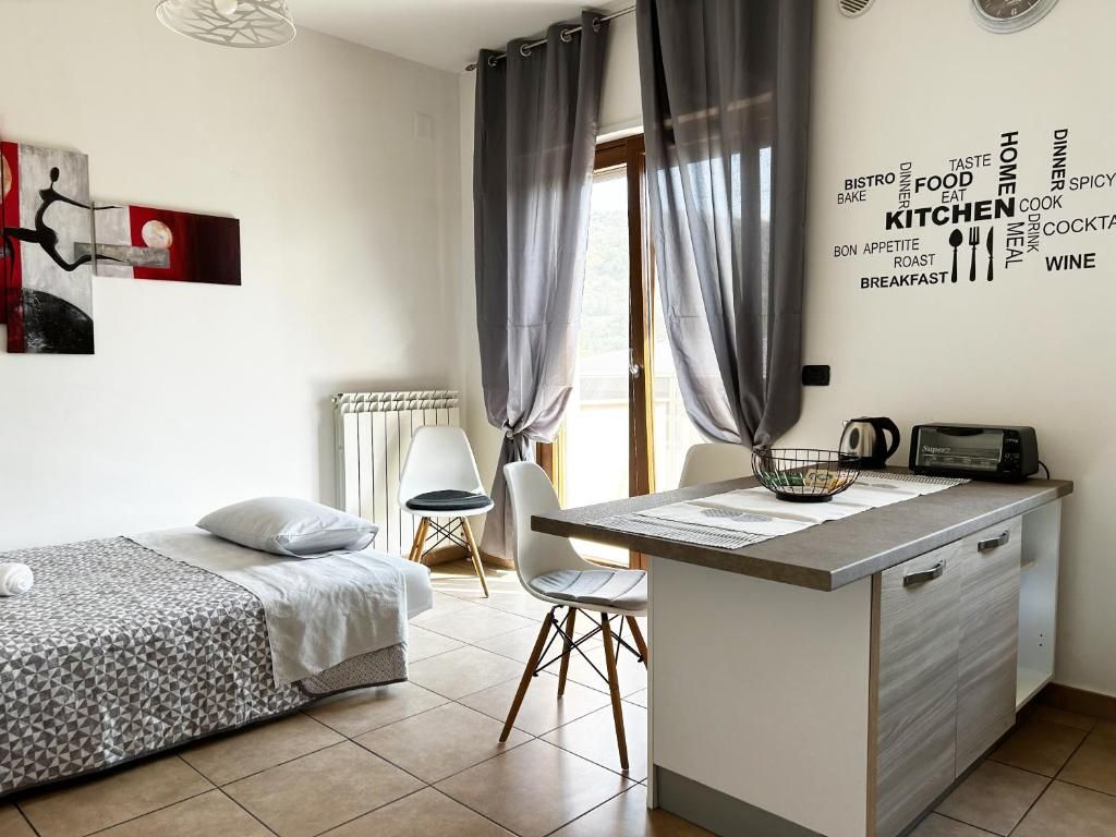 Una habitación pequeña con cama, una kitchenette y un comedor.