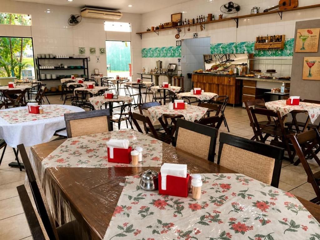Un restaurante con varias mesas, sillas y una zona de cocina.