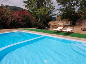 A clear blue swimming pool with two lounge chairs and a small table. - Tramonti d'Agrumi Annex (Naso)