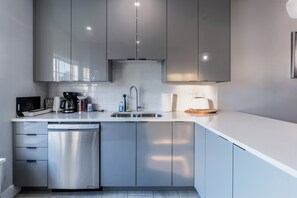 A modern kitchen with stainless steel appliances, a dishwasher, and a sink. - 4-bedroom Townhouse With AC Close to downtown (Dartmouth)