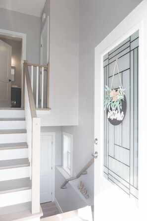 A staircase leading to a second floor with a welcome sign and a decorative plant. - 4-bedroom Townhouse With AC Close to downtown (Dartmouth)